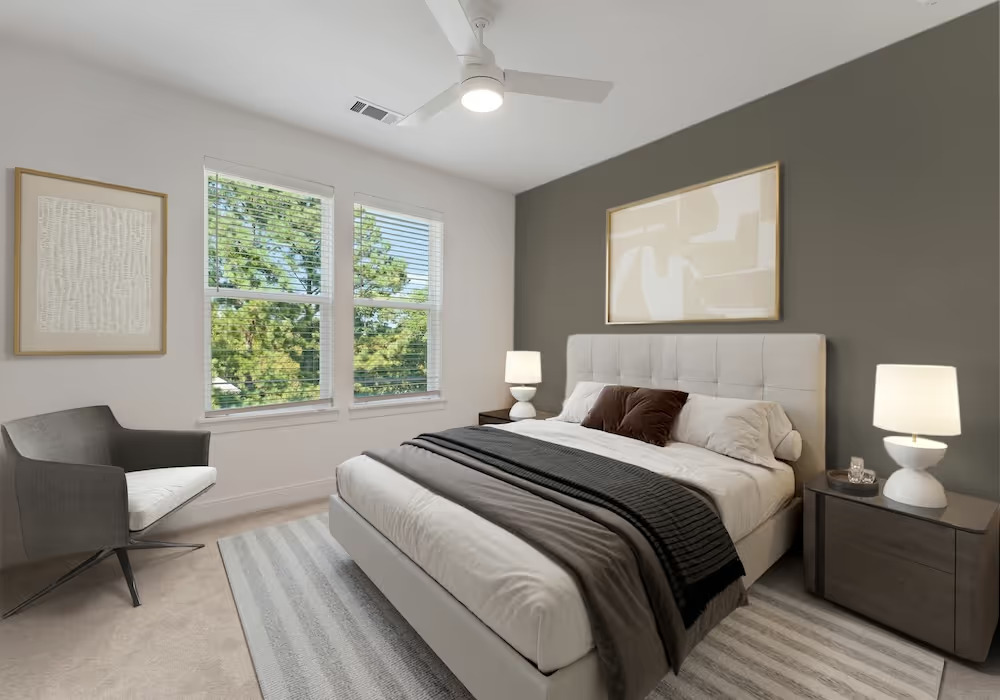 bedroom in townhome including large windows, bed, and ceiling fan