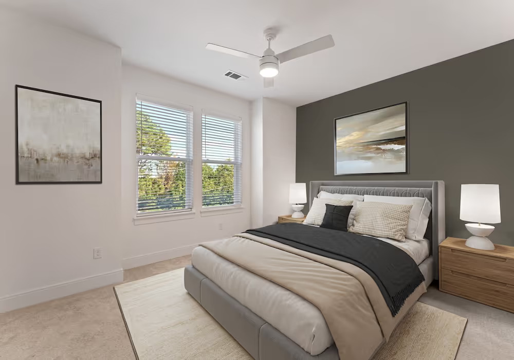 bedroom in townhome including large windows, bed, and ceiling fan