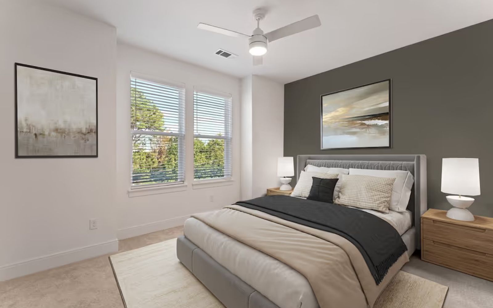 bedroom in townhome including large windows, bed, and ceiling fan