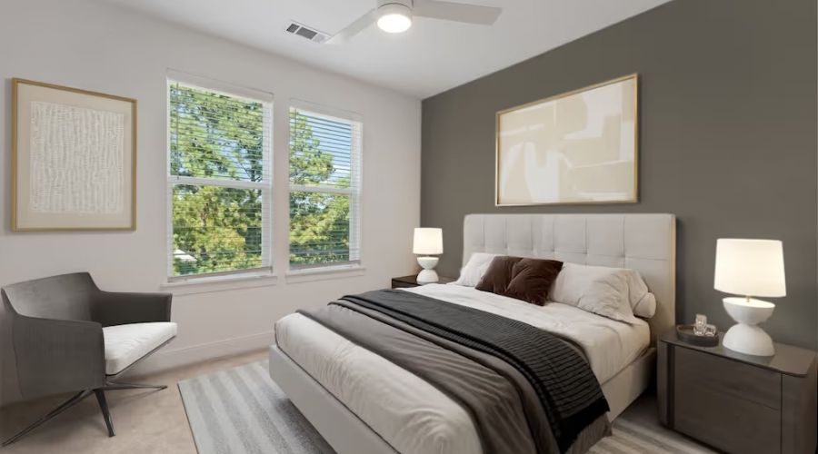 bedroom in townhome including large windows, bed, and ceiling fan