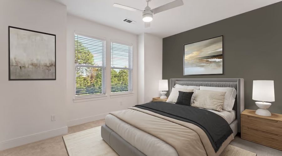 bedroom in townhome including large windows, bed, and ceiling fan