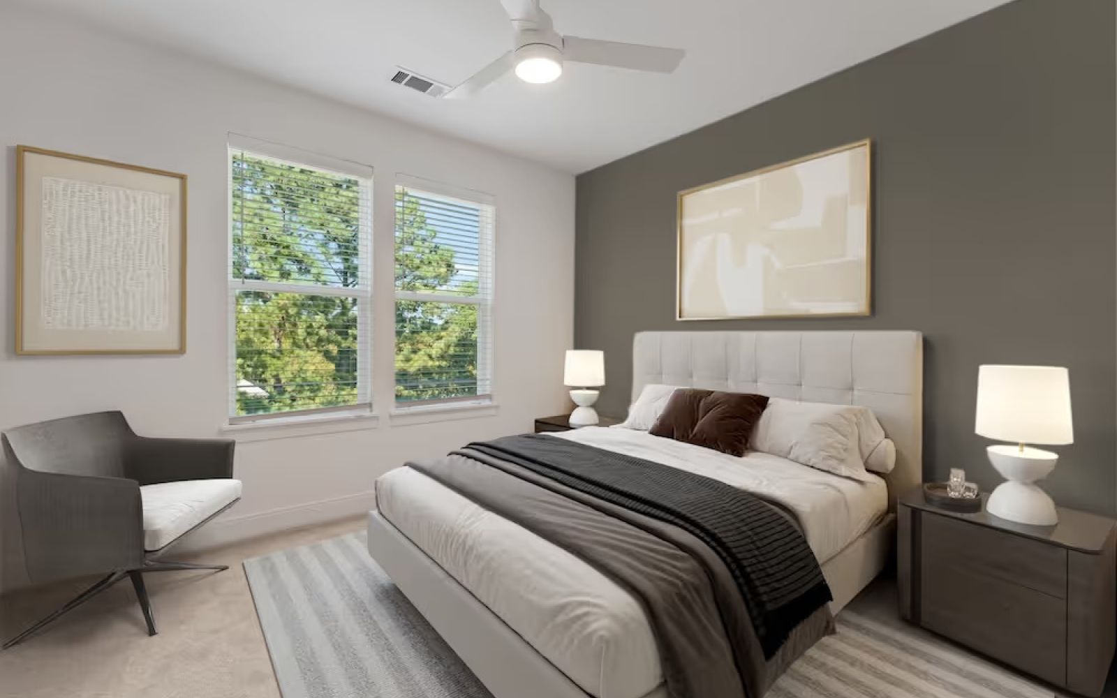 bedroom in townhome including large windows, bed, and ceiling fan